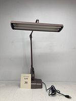 Front view of the vintage Dazor 2324 desk lamp showing the full articulating arm and fluorescent light head with plug and cord.
