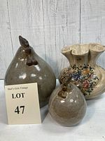 Photo showing the mother chicken and chick pottery figurines alongside the floral Italian vase, all displayed on a white surface with a wooden background.