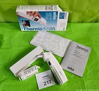 Thermometer complete with original box, clear plastic tray, instruction manual, battery, and thermometer tip covers.