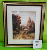 Full framed print of a rural landscape with cottages, autumn trees, and a country lane, against a green background.