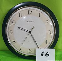 Image of the Daniel Dakota wall clock showing front face and details of clock hands, numbers, and branding.