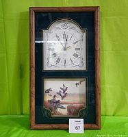 Full view of the Ingraham wall clock showing both the clock face and mallard duck artwork beneath, framed in wood against a green background.