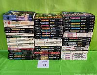 Front view of 53 softcover Mack Bolan The Executioner novels stacked in 5 neat piles. Titles visible on spines with distinctive styling and publication years running mostly through 1983-2001.