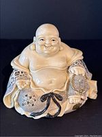 Front view showing smiling Laughing Buddha with detailed robe and visible hand-painted patterns and textural elements