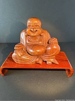 Front view of the hand carved vintage Mahogany Laughing Buddha figurine showing smiling expression and rounded belly