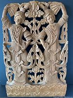 Front view of the detailed high relief Indian carving in mahogany depicting two figures with floral patterns