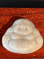Front view of the hand carved Happy Buddha green jade pendant showing detailed smooth carving and smiling face.
