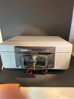 Front view of the closed gray SentrySafe fire safe, model 1110, showing the lock with two keys inserted.