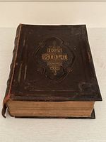 Front cover of large antique Holy Bible, leather embossed with gold text