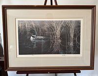 Full view of the framed print showing the loon and surrounding water and reeds, signed and numbered.
