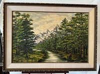 Frontal photo of large framed oil painting showing a pathway and trees leading to snowy mountains.