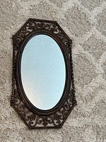 Full view of the heavy wall mirror showing octagonal frame with oval glass and overall design.