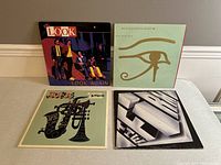 Four vintage vinyl record albums placed side by side showing front covers. Albums include Look Again, The Alan Parsons Project Eye in the Sky, Lou Donaldson, and a geometric black and white album cover.