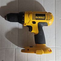 Side profile of yellow and black Dewalt DC970 cordless drill body placed on white surface showing the overall condition and design.