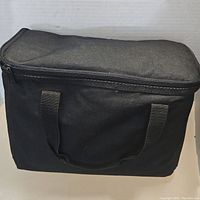 Black zippered soft carrying case with handles, shown closed.