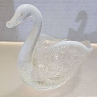 Front quarter view of the vintage Fenton opalescent glass swan figurine, showing detailed wing and neck texture.