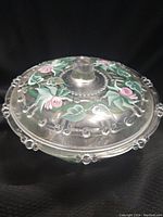 Side angle showing hand painted floral designs on the lid and bead accents around edge