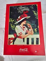 Closed original box showing vintage Coca-Cola Summer Daydreams artwork featuring a woman in white and red dress holding a bottle of Coca-Cola, red border with text.