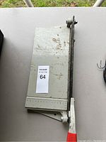 Top view of vintage metal paper cutter showing base and lever arm in resting position with visible wear and rust.