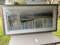 Full view of the large rectangular framed abstract artwork showing colors and drip pattern across the canvas.