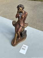 Photo of entire "Nine To Five" sculpture showing a woman in business attire sitting on an office desk with a typewriter and briefcase.