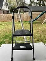 Full view of the small step ladder showing two steps and black handle support.