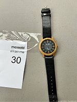 Full view of the wristwatch showing the faux wood bezel, black textured strap, and overall condition.