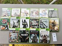 Full view of all 16 Xbox 360 games laid out on a table.