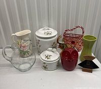 Front view of entire lot showing all ceramic and glass decorative items, including pitchers, containers, figurines, and vases