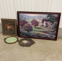Wide view of four items: large framed landscape, smaller framed portrait, two decorative plates on floor