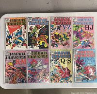 Full set of eight Marvel Comics Official Handbooks of the Marvel Universe laid flat on a table, showing detailed colorful comic book covers for character ranges A-D, V-Z, H-J, K-M, M-P, Q-S, and D-G.