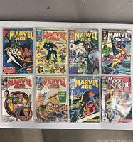 Eight Marvel comic books laid out in two rows of four, each in plastic sleeves showing different cover arts featuring Marvel superheroes and Moon Knight.
