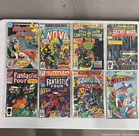 Full set of eight comic books laid out on a table showing front covers including Marvel Super Heroes Secret Wars, Guardians of the Galaxy, Fantastic Four, Green Lantern and others.