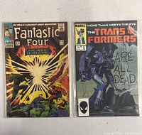 Both comics front covers in plastic sleeves showing Fantastic Four #53 and The Transformers #5.