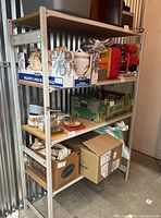 First industrial metal storage rack with items on shelves for scale and context, showing the metal frame and particle board shelving.