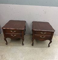 Pair of French Provincial end tables side by side against a wall showing overall design and shape.