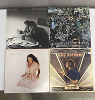 Top view of four vinyl records laid out: Billy Joel's The Stranger, Rod Stewart's A Night on the Town with illustrated crowd cover, Rita Coolidge's self-titled album, and Rod Stewart's A Night on the Town with geometric design cover.