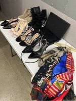 Full shot of the assortment of women's shoes in mostly size 8 along with scarves on hangers and a boxed black clutch