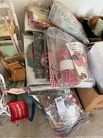 Pile of various Christmas craft and needlepoint kits in original packaging and bags