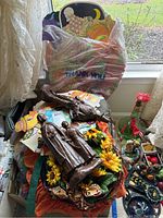 Overview of the lot showing pilgrim figurines, cardboard cutouts, fabric wreaths, and smaller decorations on a table by a window with lace curtains.