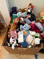 Boxed collection of TY Beanie Babies and Looney Tunes plush toys showing variety and condition.