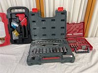Photo showing the Crescent socket set with multiple sockets, ratchet handles, and extensions in a green molded case on a white surface.