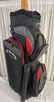 Callaway golf bag standing upright showing full side profile with black, gray, and red color scheme and multiple storage compartments.