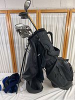 Profile photo of the golf bag filled with a set of golf clubs including irons and woods, showing club length and bag stand feature