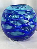 Front view of the blue orb glass vase showing raised swirl texture details
