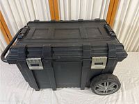 Overall view of the Husky rolling toolbox showing body, wheels, handle, and metal latches.