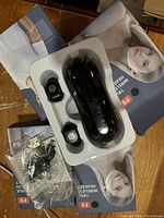 Items include four unopened or open box sets of F9 true wireless earbuds, each with a black charging case and earbuds, along with accompanying USB charging cables visible in packaging.