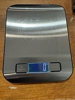Top view of the digital kitchen scale displaying a zero reading on the digital screen with stainless steel surface.
