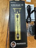 Photo of the box showing the MeKeco Vintage T9 Professional Trimmer with engraved lion and digital display on handle