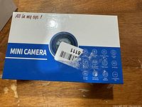 Closed box of the mini camera showing branding and key features icons.